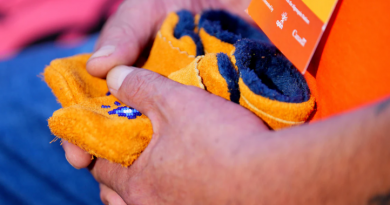 Une personne tient des mocassins.