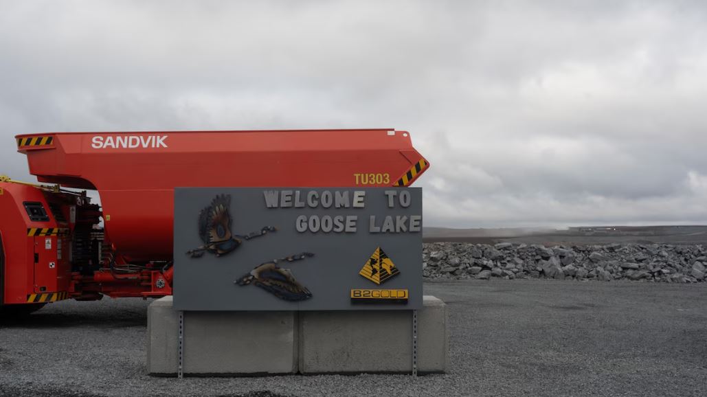 Un panneau marquant l'entrée du site de la mine Goose cache partiellement un camion rouge. 