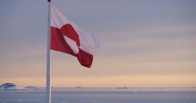 Le drapeau du Groenland vole dans le vent, devant un coucher de soleil, à Nuuk, en mars 2022.