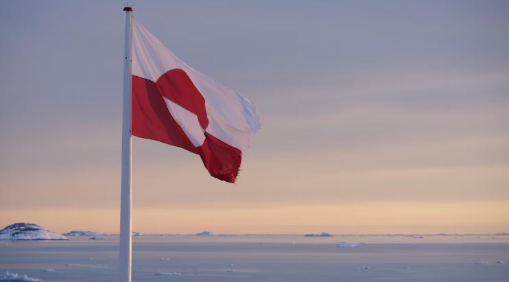 Le drapeau du Groenland vole dans le vent, devant un coucher de soleil, à Nuuk, en mars 2022.