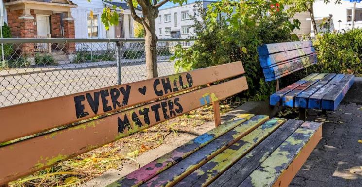 Un banc où il est écrit en anglais « Chaque enfant compte ».