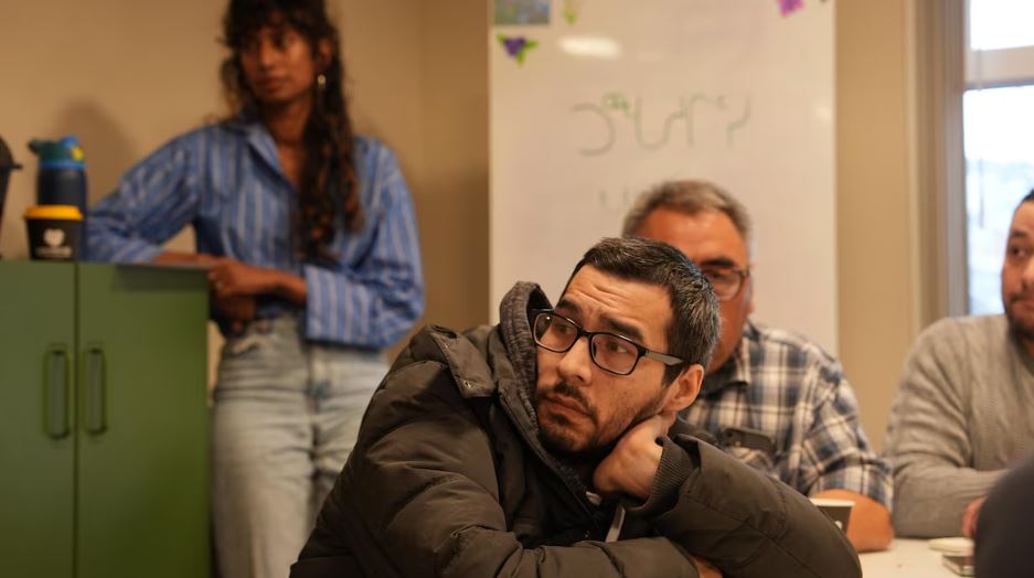 Un homme attentif, en arrière-plan, Sindu Govindapillai.