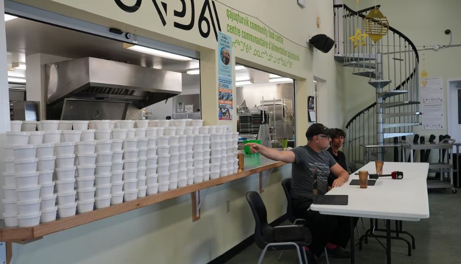 Un homme montre des plats à emporter.