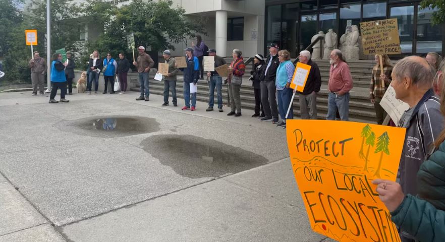 Des personnes avec des pancartes devant le Palais de justice de Whitehorse, en août 2023.