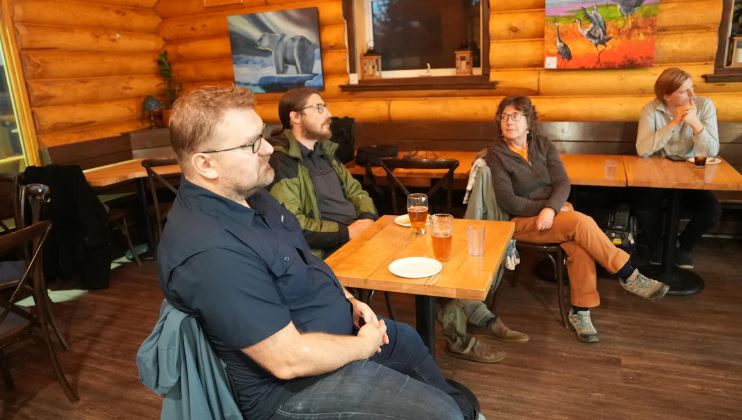 Trois personnes assises à une table.