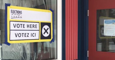 Une pancarte collée sur une fenêtre annonçant qu'il est possible de voter à cet emplacement.