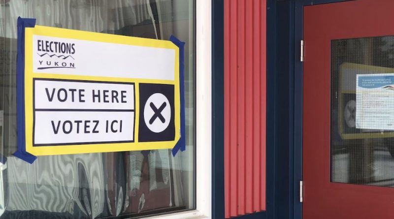 Une pancarte collée sur une fenêtre annonçant qu'il est possible de voter à cet emplacement.
