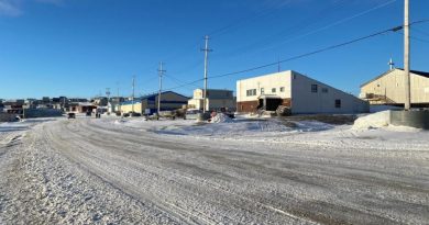 Une rue enneigée bordée de bâtiments et de maisons.