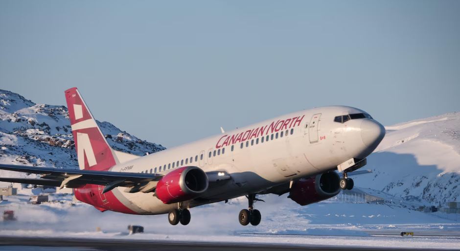 Un Boeing blanc et rouge décolle d'un aéroport nordique enneigé par une journée ensoleillée et sans nuages, le 3 mars 2024.