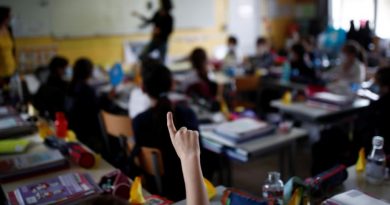 Un enfant lève le doigt dans une salle de classe.