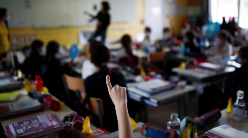 Un enfant lève le doigt dans une salle de classe.