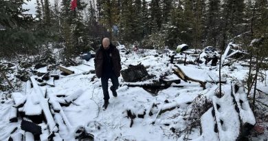 Un homme est debout au milieu de décombres.