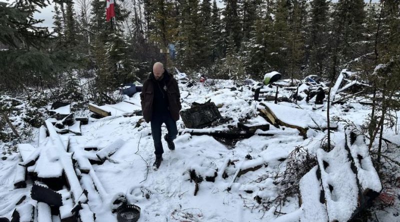 Un homme est debout au milieu de décombres.