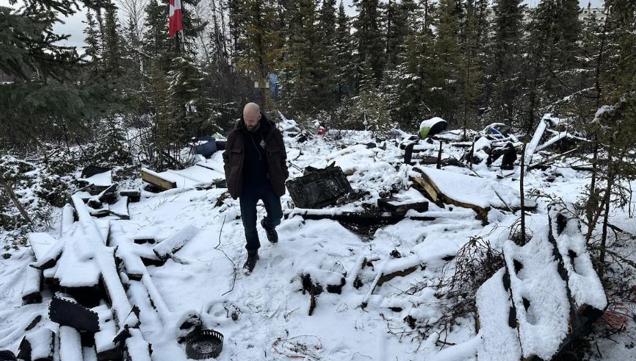 Un homme est debout au milieu de décombres.