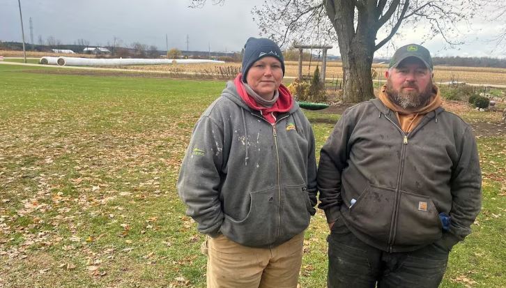 Deux personnes posent sur leur ferme.