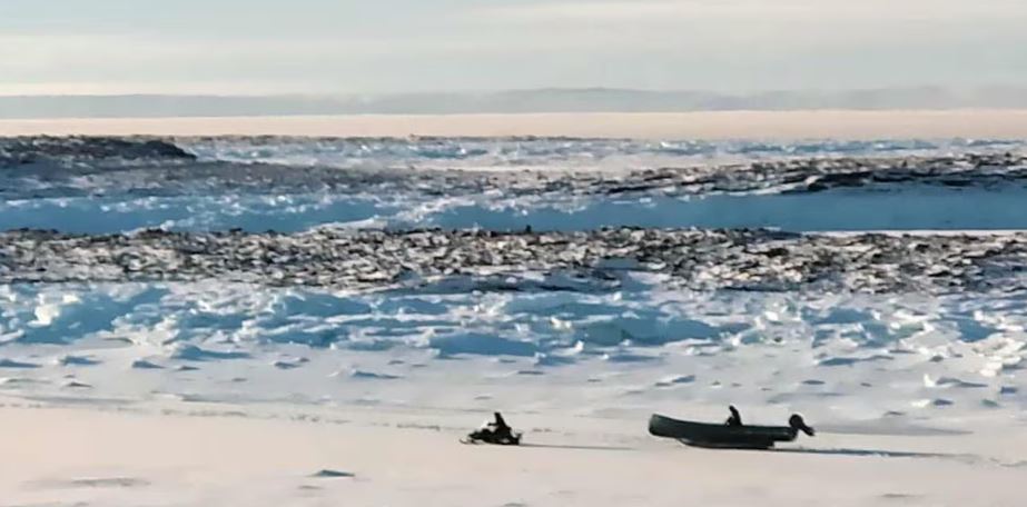 Une personne en motoneige au loin.