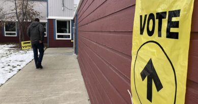 Un électeur se dirige vers l'entrée d'un lieu de scrutin marqué par des affiches.