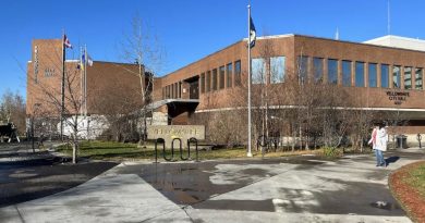 Une personne marche devant l'hôtel de ville de Yellowknife.