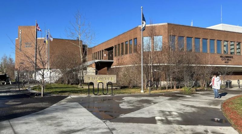 Une personne marche devant l'hôtel de ville de Yellowknife.