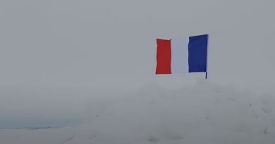 Un drapeau flotte sur une étendue de glace.