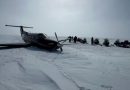 Un avion à hélices sur la neige entouré de gens et de motoneiges, le 7 mai 2024.