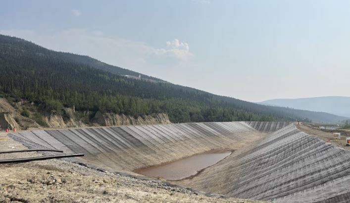 Un bassin à ciel ouvert au pied d'une montagne.
