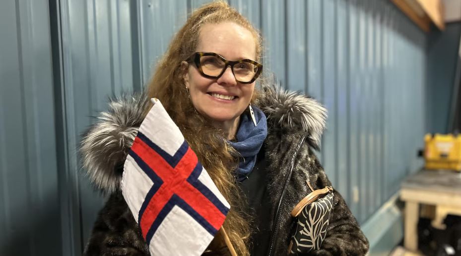 Une femme qui tient un drapeau des îles Féroé.