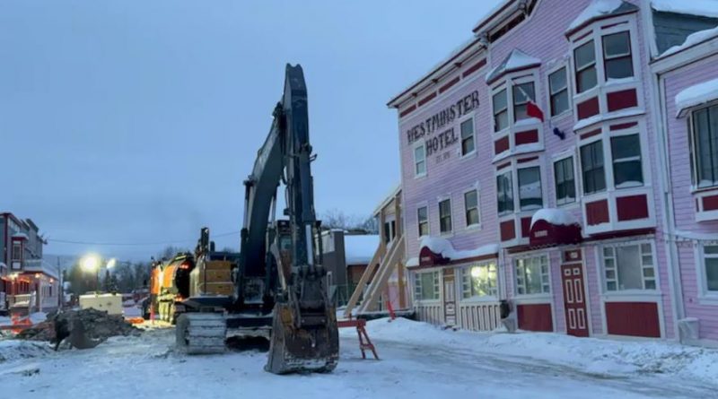 Une pelle mécanique travaille à creuser la chaussée en face de l'hôtel Westminster.