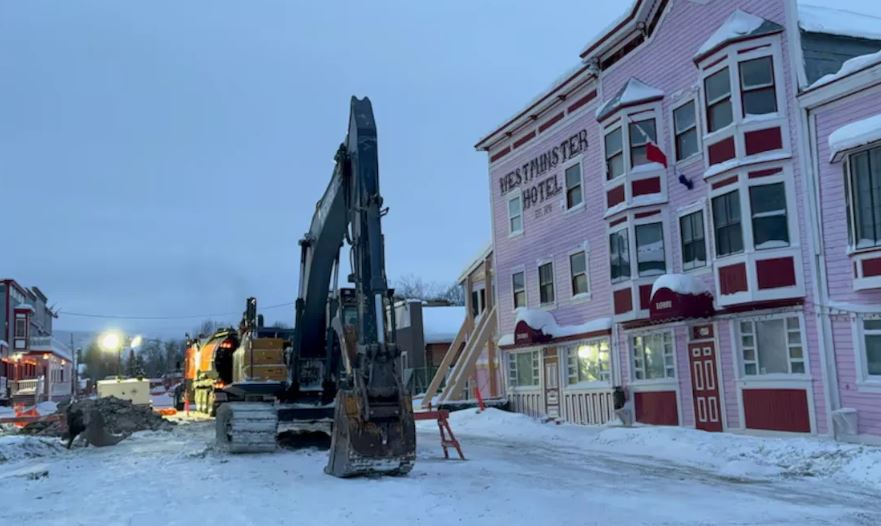 Une pelle mécanique travaille à creuser la chaussée en face de l'hôtel Westminster.