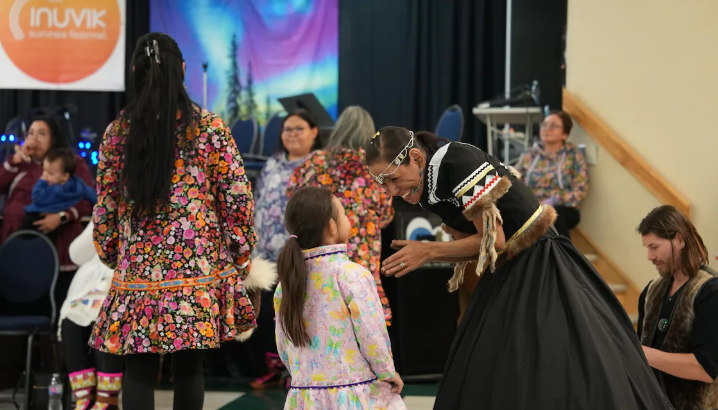 Une ainée félicitant une petite fille à la fin d'une danse.