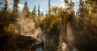 De la vapeur s'échappe d'une piscine d'eau chaude dans laquelle des touristes se baignent.
