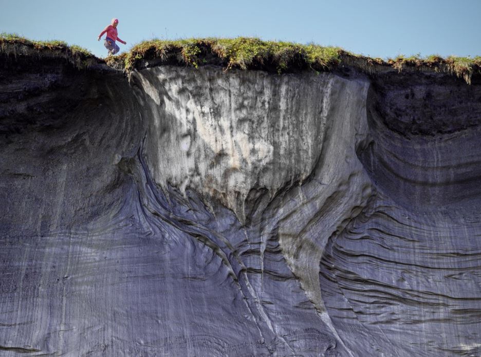 Vue en contre-plongée d'une personne au bord d'une falaise.