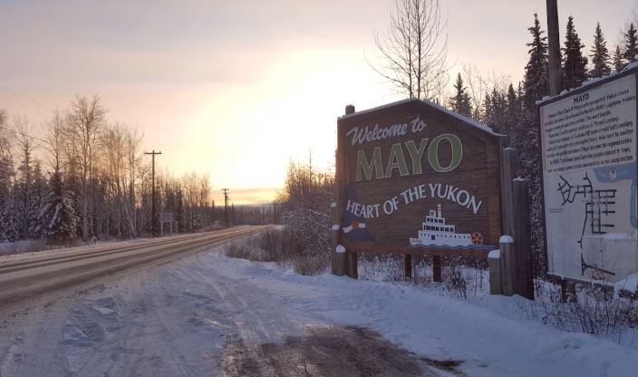 Enseigne à l'entrée du village de Mayo, au Yukon, en hiver, sur laquelle on peut lire, en anglais, Welcome to Mayo, Heart of the Yukon.