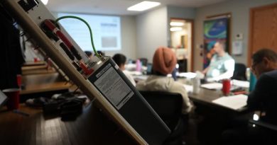 Un transformateur électrique au premier plan avec une classe en arrière-plan.