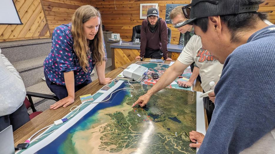 Un groupe de personnes regardent une carte géographique.