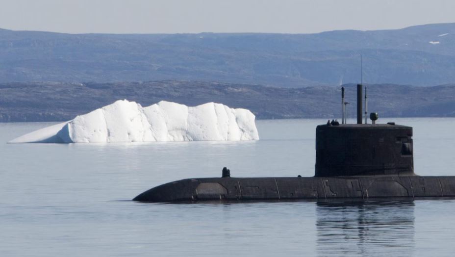 Un sous-marin faisant surface près d'un iceberg.