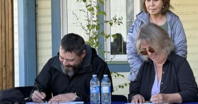 Deux personnes à une table signent des papiers.