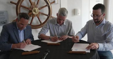 Les trois premiers ministres du Nord en train de signer un document à une table.