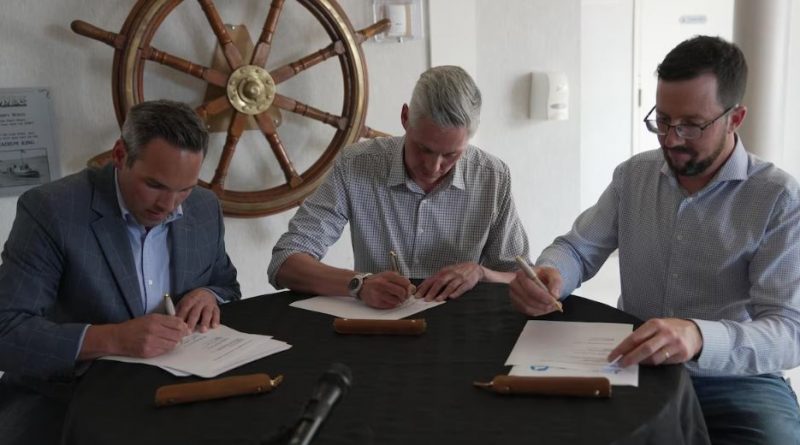 Les trois premiers ministres du Nord en train de signer un document à une table.