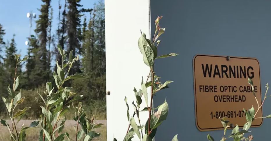 Boîte indiquant la présence de fibre optique près d'une route.