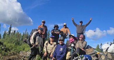 Neuf personnes avec leur équipement de randonnée.