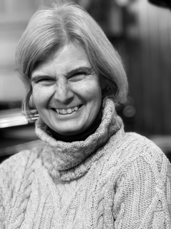 Une femme regarde la caméra en souriant.