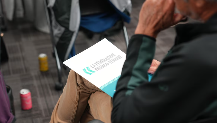 Photo d'un membre de dos avec un dossier de la FFT sur les genoux.