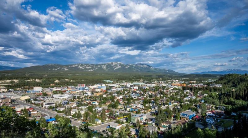 Une vue en hauteur de la ville de Whitehorse mélangeant arbres et bâtiments.