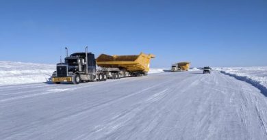 Des camions sur une route glacée et enneigée.
