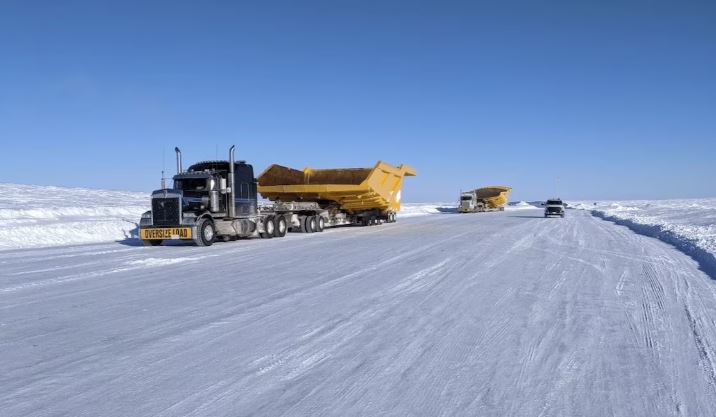 Des camions sur une route glacée et enneigée.