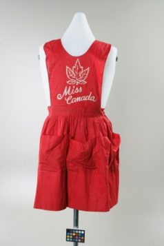 无数加拿大女子穿着这样的围裙卖25分一张的邮票，为军队筹得3亿多加元。/Canadian War Museum