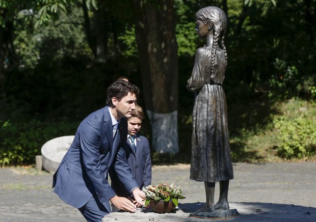 特鲁多父子在乌克兰大饥荒受害者纪念碑前献花。(AP Photo/Sergei Chuzavkov）